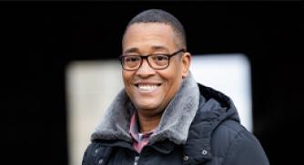 An image of Kevin Wake, a person living with sickle cell disease, smiling at the camera