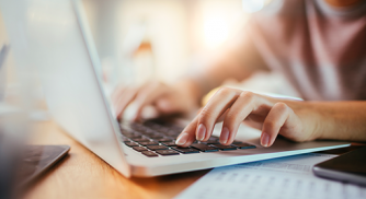 A woman typing on her laptop